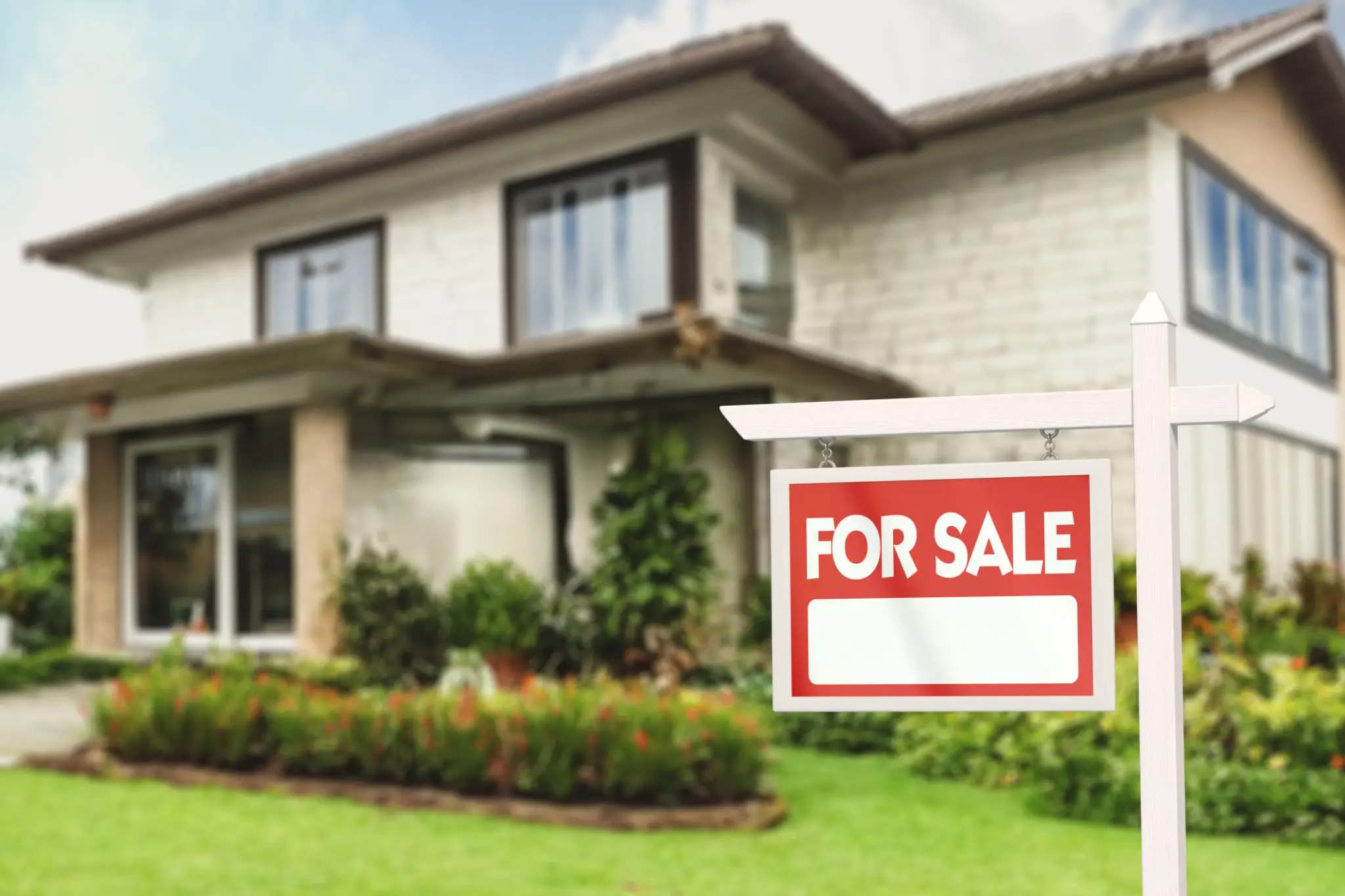 A house with a red and white 'For Sale' sign in the front yard.